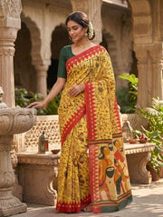 Mustard yellow folk art print mulmul cotton saree with red border, worn by model
